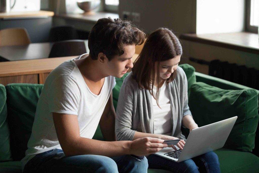 Couple searching online for how to verify a builder before buying a property.
